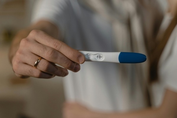 woman showing positive pregnancy test